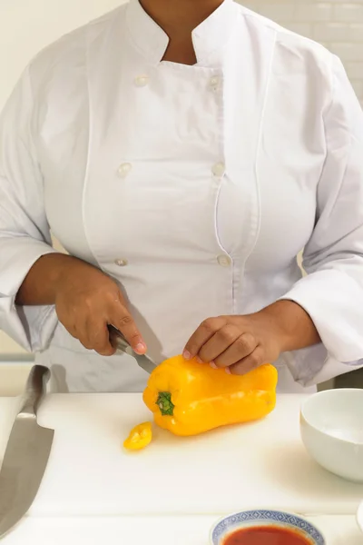 Шеф-повар режет желтый перец — стоковое фото
