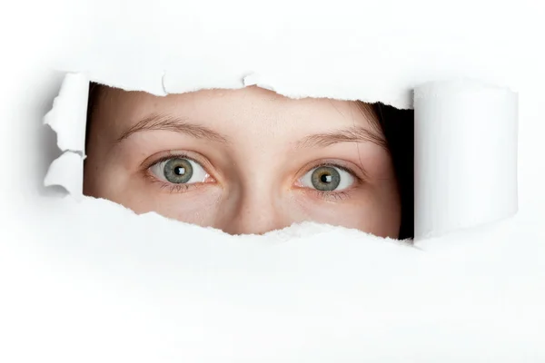 stock image Peeking through torn paper hole