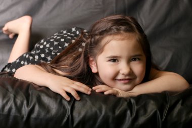 Beautiful Young Child Smiling Lying on a clipart