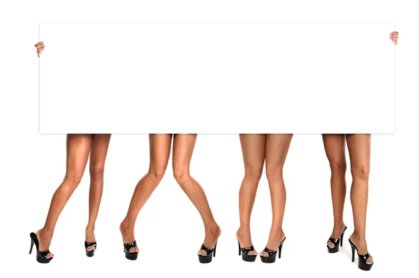 Kvinnors ben håller upp ett tomt tecken — Stockfoto