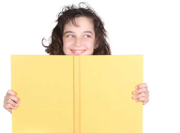 Маленькая школьница смотрит на свою книгу — стоковое фото