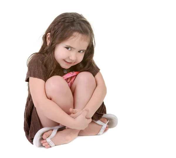 Uttrycksfulla barn kramar hennes ben — Stockfoto