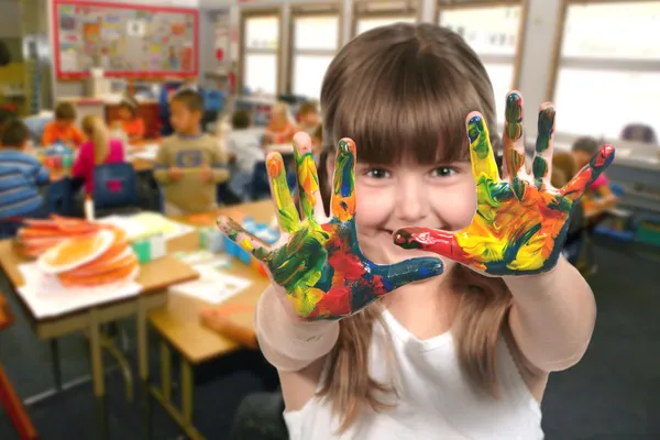 School-leeftijd kind schilderen met haar handen Stockfoto
