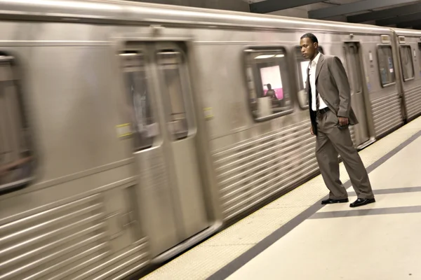 Schwarzer Geschäftsmann beobachtet, wie die U-Bahn vorbeifährt — Stockfoto