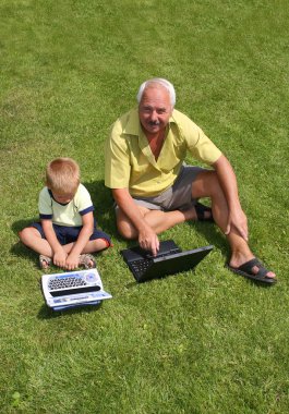Grandfather and grandson working on lapt clipart