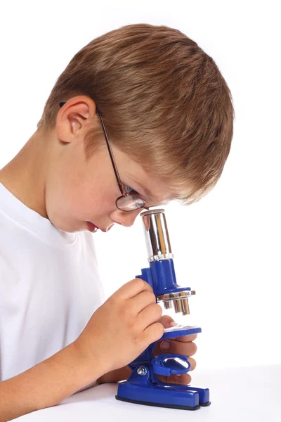 这个男孩用显微镜 — 图库照片