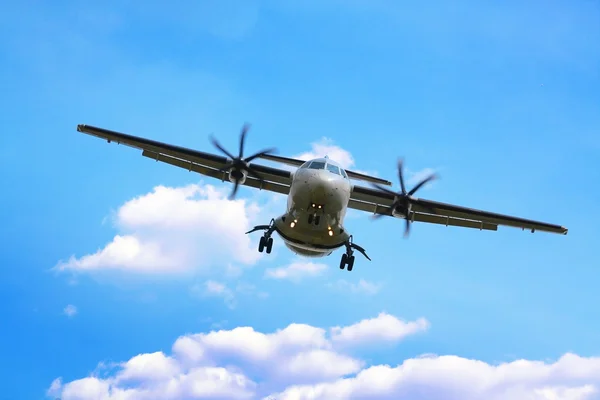Propeller airplane landing in cloudy sky — Stock Photo, Image