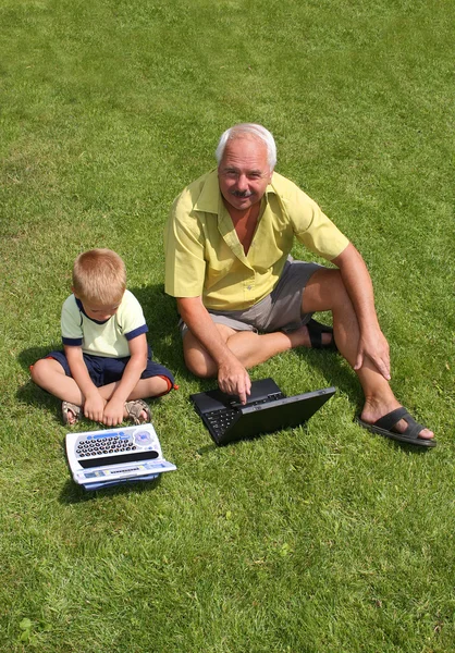 Großvater und Enkel arbeiten am Laptop — Stockfoto