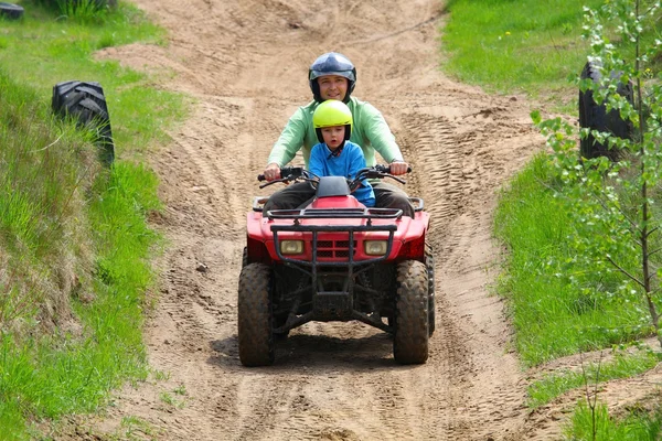 Dad with son riding a quad bike — Stock Photo, Image