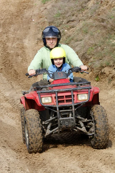Pai com filho montando uma moto quad — Fotografia de Stock