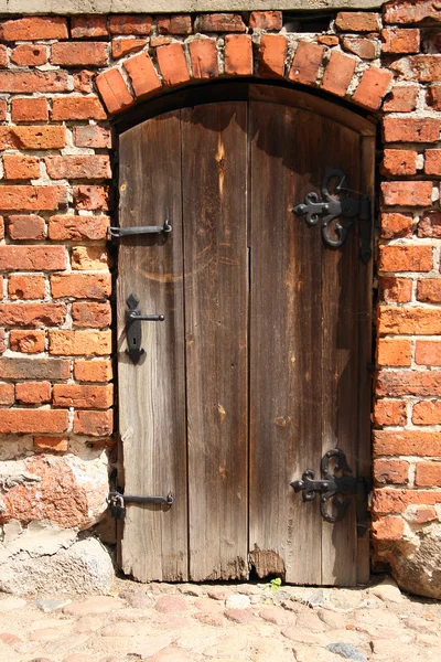 Старая, гнилая дверь в кирпичной стене — стоковое фото