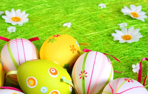Huevos de Pascua con manzanilla sobre hierba verde fresca — Foto de Stock