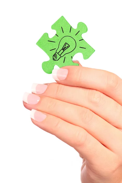 Hand holding drawn light bulb on puzzle — Stock Photo, Image