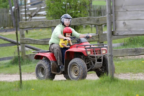 Papá con hijo montando un quad —  Fotos de Stock