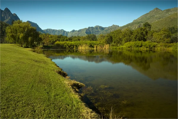 Smooth lake reflecting mountain range — Stock Photo, Image