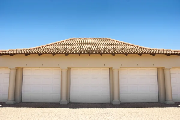 Белые тройные гаражные двери — стоковое фото