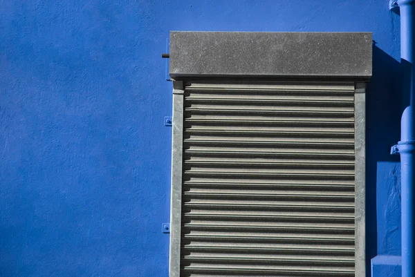 Sluitertijd roldeur in blauwe muur — Stockfoto