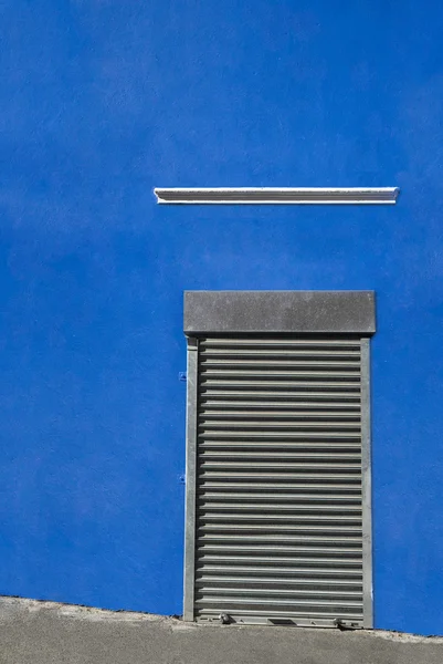 Porta do obturador do rolo na parede azul — Fotografia de Stock