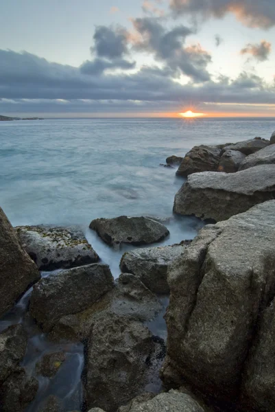 Закат над скалистым пляжем — стоковое фото