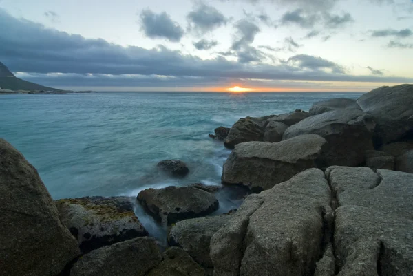Puesta de sol sobre la playa rocosa — Foto de Stock