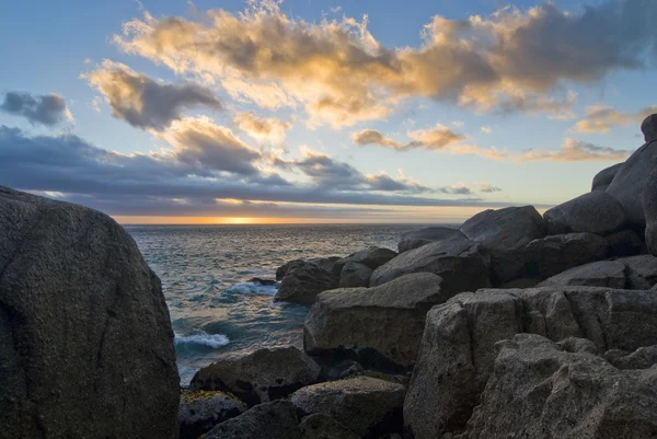 Západ slunce nad skalnatou pláž — Stock fotografie