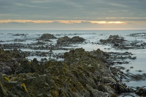 波のクラッシュに沈む夕日 — ストック写真