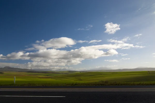 Открытая дорога с облаками — стоковое фото