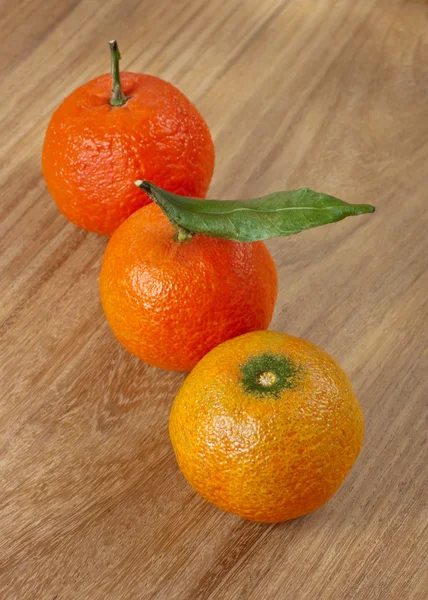 Three mandarins on wooden table — Stock Photo, Image