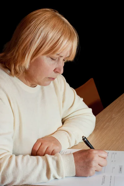 stock image Senior woman filling in an document