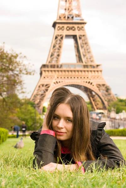 Молодая женщина рядом с Эйфелевой башней — стоковое фото