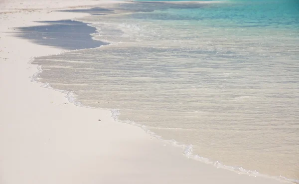 Vågor stänker på en vit sandstrand — Stockfoto