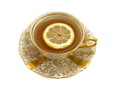 Gold porcelain cup with tea and lemon clipart