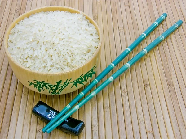 Wooden bowl with rice and chopsticks — Stock Photo, Image