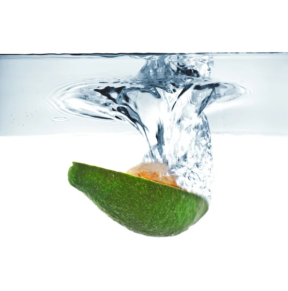 Авокадо падает в воду — стоковое фото