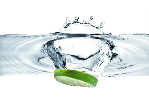 Lime slice falling into water — Stock Photo, Image