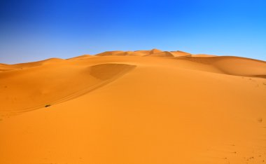 Sand dunes and cloudless blue sky clipart