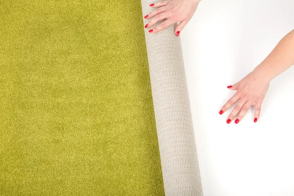 Kobiece ręce rozwijania dywan — Zdjęcie stockowe