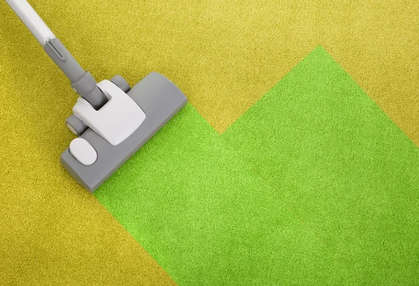Пылесос на зеленом ковре — стоковое фото