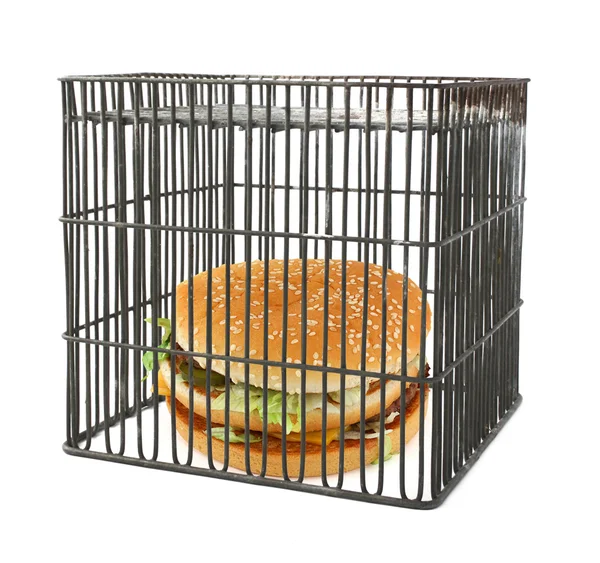Diet concept - fast food behind bars — Stock Photo, Image