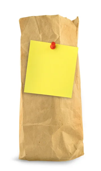 Saco de papel marrom com nota amarela — Fotografia de Stock