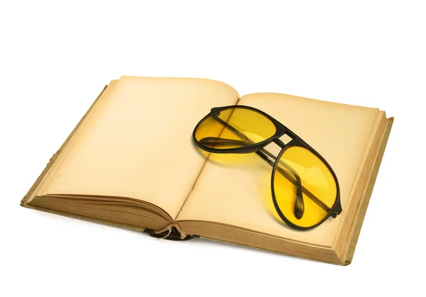 Libro con gafas de sol amarillas sobre blanco — Foto de Stock