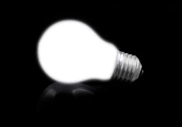 Close-up of lit light bulb on black — Stok fotoğraf