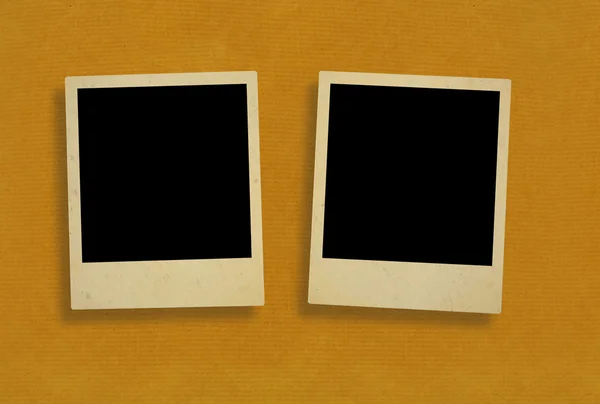 Dva staré fotorámečky proti hrubý papír — Stock fotografie