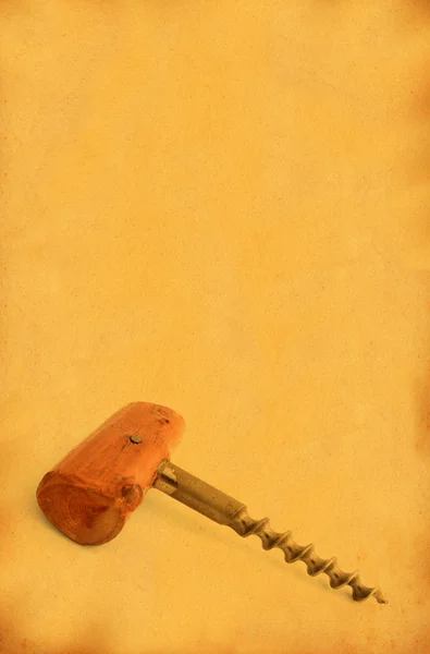 Corkscrew against stained old paper — Stock Photo, Image