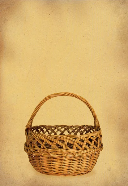 Wicker basket against stained paper — Stock Photo, Image