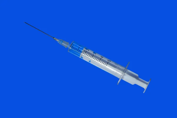Syringe on blue background — Stock Photo, Image