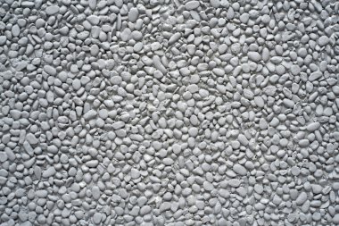 Grey painted pebble stones on a wall clipart