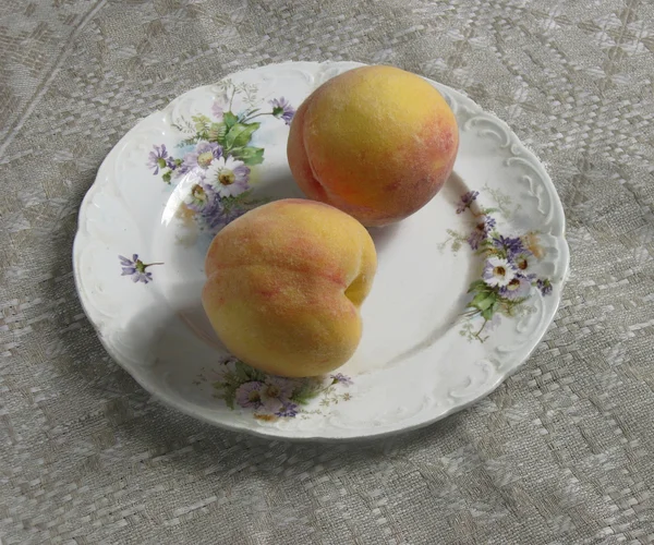 Två peachs på antika plattan — Stockfoto