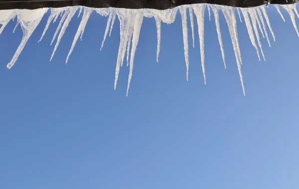 Çatıdan aşağı asılı buz sarkıtları — Stok fotoğraf
