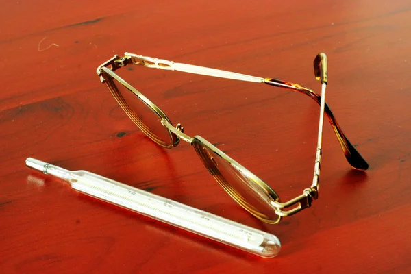 Lékařský teploměr a brýle — Stock fotografie